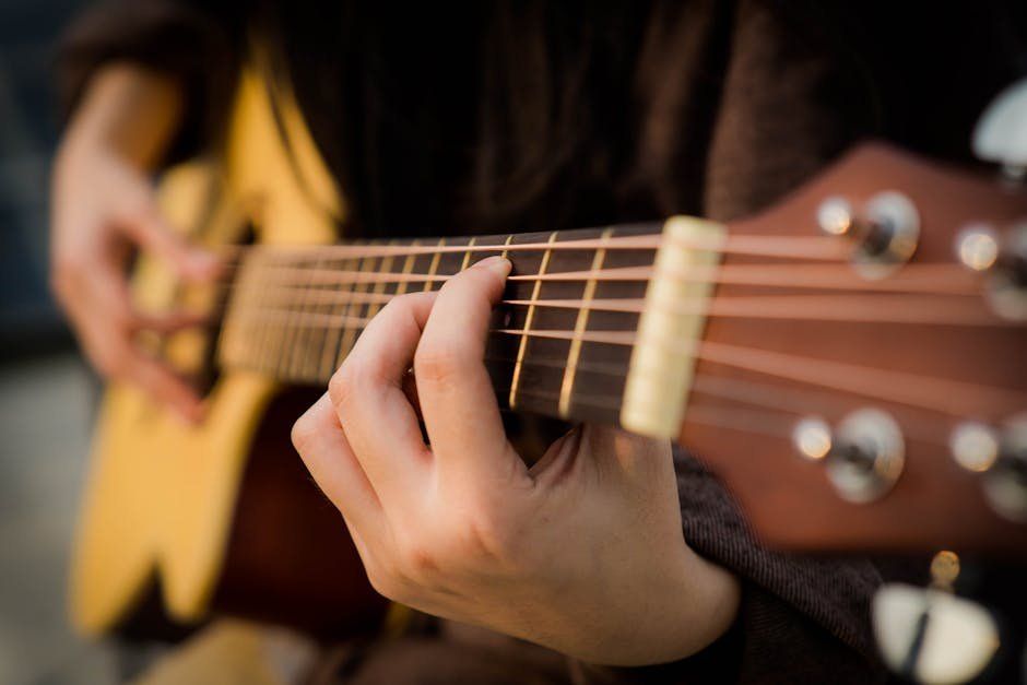 Close up picture of a person playing guitar