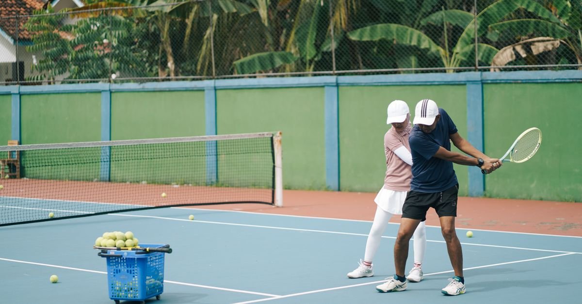 Tennis coach explaining technique to children