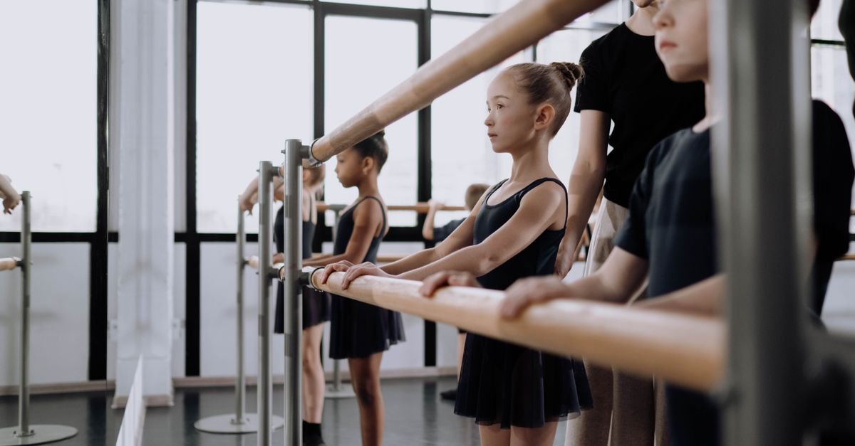 Children practising ballet at the barre in a dance studio