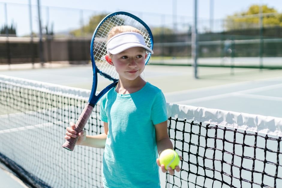 Young boy swinging a tennis racket on court